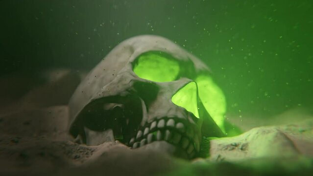 A glowing green skull in sand underwater with light coming from the surface