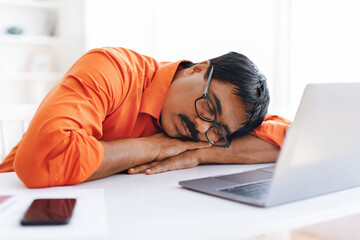 Mature indian man employer sleeping at workplace - obrazy, fototapety, plakaty