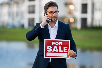 Real estate agent hold american house sale sign. Real estate sale or property investment concept....