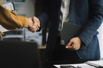 Businessmen shake hands after agreeing to start a new project successfully.