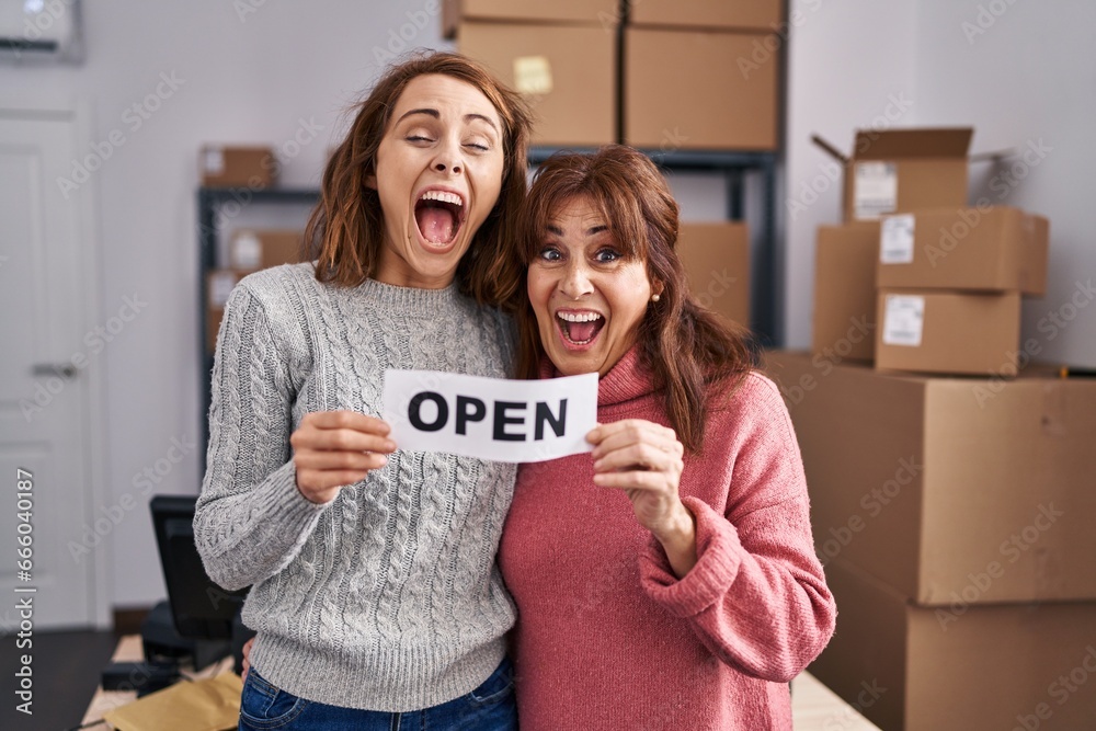 Sticker two women working at small business ecommerce holding open banner smiling and laughing hard out loud