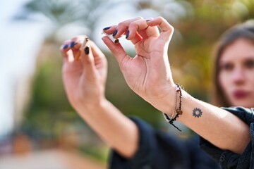 Young blonde woman breaking cigarette at park