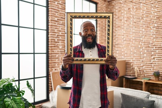 African american man putting face in empty frame celebrating crazy and amazed for success with open eyes screaming excited.