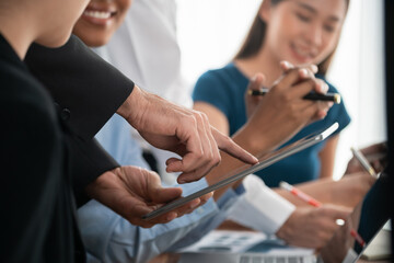 Diverse business people work together, discuss in corporate office. Professional teamwork discussing and pointing at laptop. Modern multicultural office worker. Concord