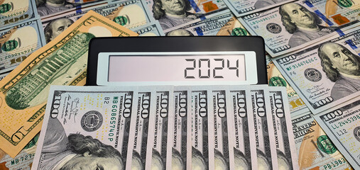 Elections and new challenges in 2024. Calculator on the background of 100 US dollar banknotes....