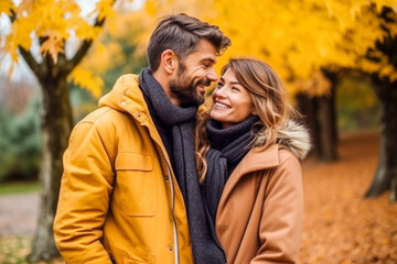 Smiling couple walking through the park in autumn
