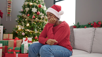 Obraz na płótnie Canvas African american woman celebrating christmas with sad expression at home