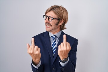 Caucasian man with mustache wearing business clothes showing middle finger doing fuck you bad...