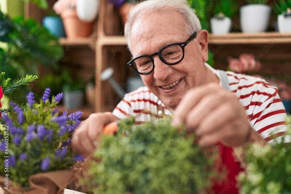 Poster Middle age grey-haired man florist cutting plant at flower shop