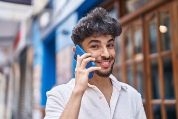 Young arab man smiling confident talking on the smartphone at street