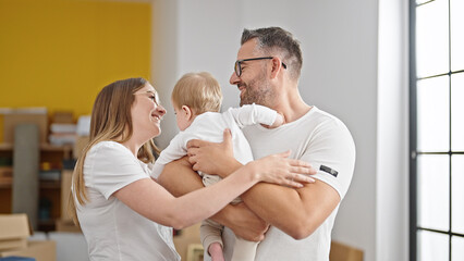Obraz premium Family of mother, father and baby smiling together at new home