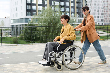 Woman having fun with her friend with disability during their walk in the city