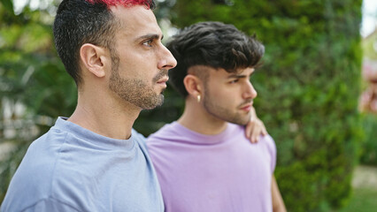 Fototapeta premium Two men couple hugging each other with relaxed expression at park