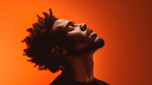 A stylish african american man in profile, orange background