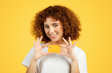 Cheerful young caucasian lady show credit card, embodying youthful financial independence