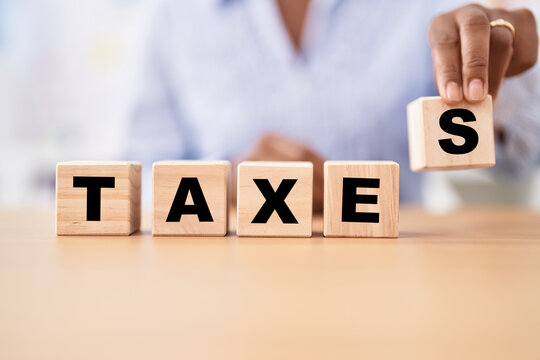 Black woman holding cubes with taxes word on the table