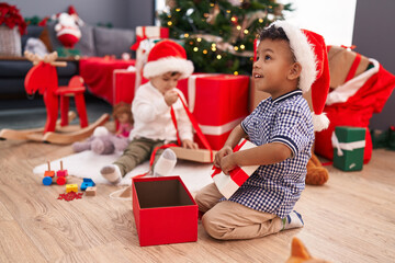 Obraz na płótnie Canvas Adorable boys celebrating christmas unpacking gift at home