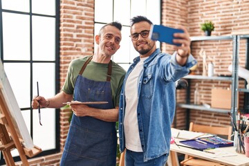 Two men artists smiling confident make selfie by smartphone at art studio