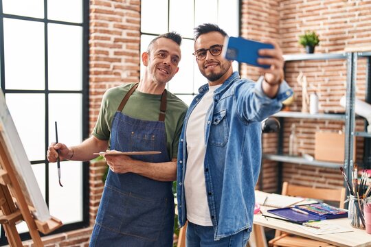 Two men artists smiling confident make selfie by smartphone at art studio