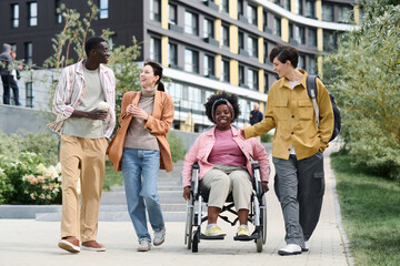 African American woman with disability walking together with her friends outdoors