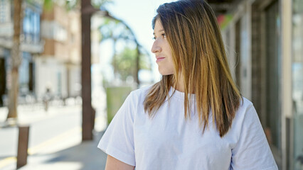 Young blonde woman looking to the side with serious expression at street