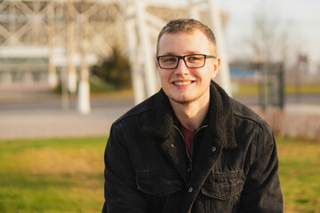 portrait of young handsome man wearing eyeglasses in the street on a summer day