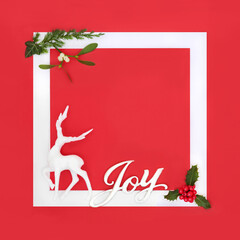 Christmas eve joy sign and reindeer bauble with winter greenery background frame. Festive symbols...