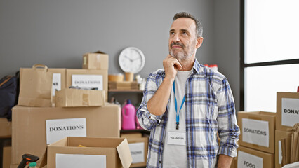 Serious middle age man, with grey hair and beard, a thoughtful volunteer at charity center,...