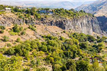 Fototapeta na wymiar houses of village of Garni on cliff over of Azat River gorge in Gegham mountains of Armenia