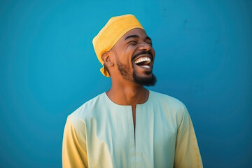 happy Moroccan man with typical moroccan tunic standing against blue wall - obrazy, fototapety, plakaty