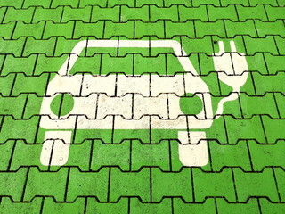 Parkplatz in Grün mit Piktogramm in Weiß für ein Elektroauto an einer Tankstelle mit Ladestation für Strom in Bielefeld im Teutoburger Wald in Ostwestfalen-Lippe - obrazy, fototapety, plakaty