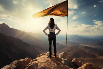Fototapeten businesswoman standing top of mountain winner orange flag on back view © pics3