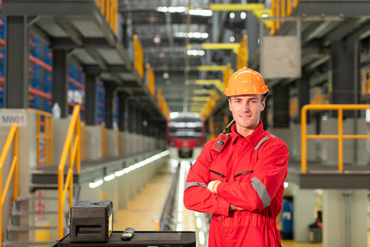 Portrait of engineer using repair tools of the electric train industry There is an electric train in the train repair factory as the background image.