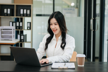 Asian businesswoman working in the office with working notepad, tablet and laptop documents .