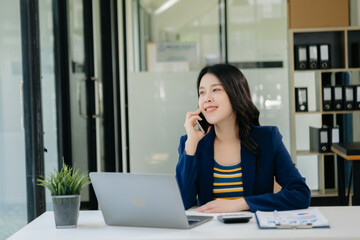 Obraz premium Asian business woman typing laptop and tablet Placed at the table at the office.