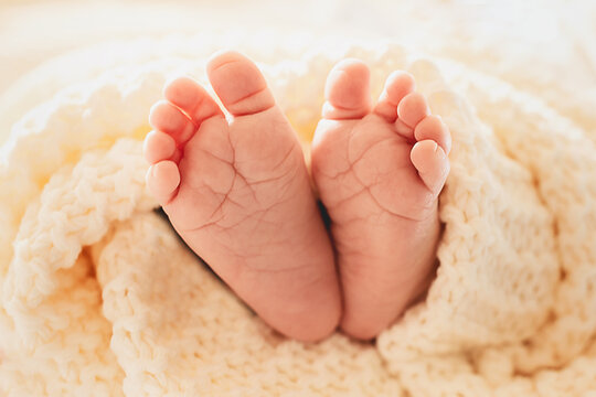 Babyf&uuml;&szlig;e, umwickelt mit gestrickter Decke.