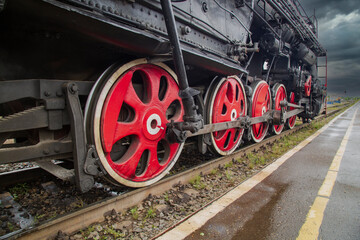 An old steam locomotive of the early 20th century on the railway track.