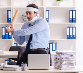 Young injured male employee working in the office