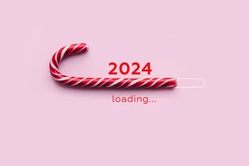 Tuinposter Striped candy cane and lettering 2024 loading on pink background. Concept of waiting for seasonal holidays. Copy space, selective focus © olyphotostories