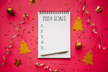 New Year goals List 2024 with notebook written in handwriting about plan listing of new year goals and resolutions setting. flat lay style. Christmas planning concept - obrazy, fototapety, plakaty