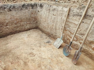 Pit in the ground. Digging a pit. The shovels in the pit. Earthworks, digging trench.