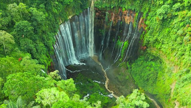 Around on Tumpak Sewu waterfall located in Lumajang, East Java, Indonesia. Aerial drone view 4K.