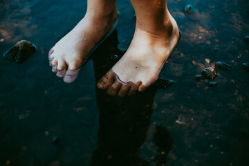 Kind mit Füßen im Wasser