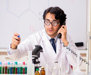 Young funny chemist in front of white board