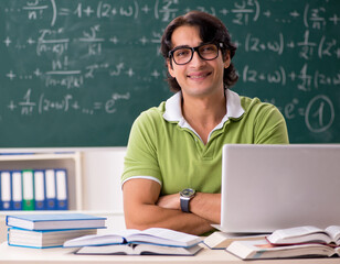 Handsome student in front of chalkboard with formulas