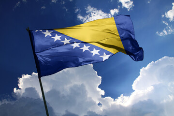 national flag of Bosnia and Herzegovina waving in the wind on a clear day.