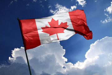 national flag of Canada waving in the wind on a clear day.