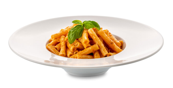 Macaroni rigati pasta with tomato sauce. Italian pasta called sedani rigati (striped celery) with tomato pesto and basil leaves in white dish isolated