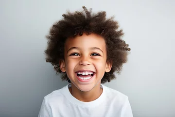 Fotobehang A professional portrait studio photograph featuring an adorable, mixed-race young boy with immaculately clean teeth, radiating joy with laughter and smiles. This image is isolated on white background © hisilly