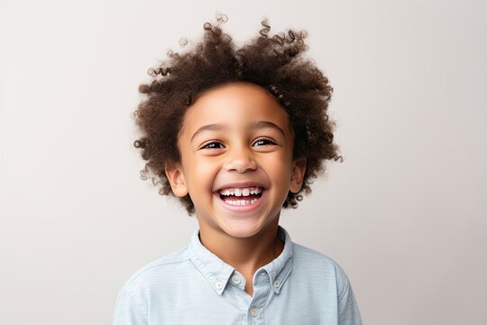 A professional portrait studio photograph featuring an adorable, mixed-race young boy with immaculately clean teeth, radiating joy with laughter and smiles. This image is isolated on white background